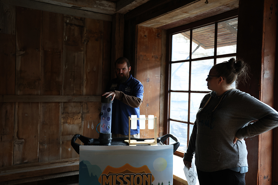 A staff member shows guests artifacts.