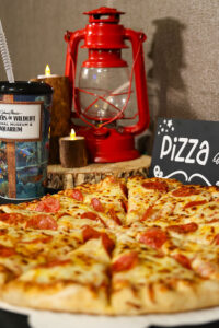 A pepperoni pizza and reusable cup from Wonders of Wildlife at a child's birthday party.